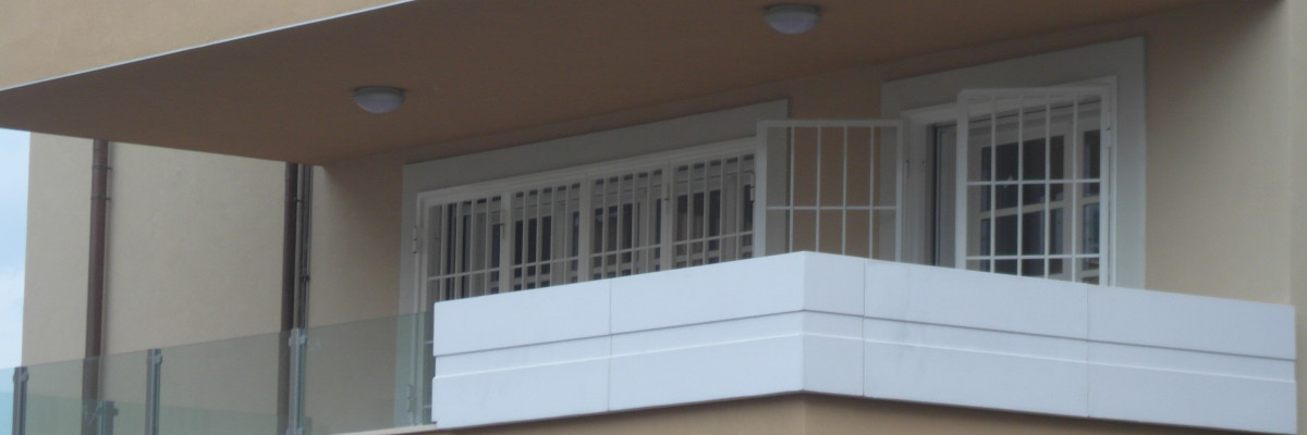 La sicurezza maggiore si ottiene con un sistema integrato di dispositivi: le inferriate non bastano Inferriate bianche su un balcone di un condominio